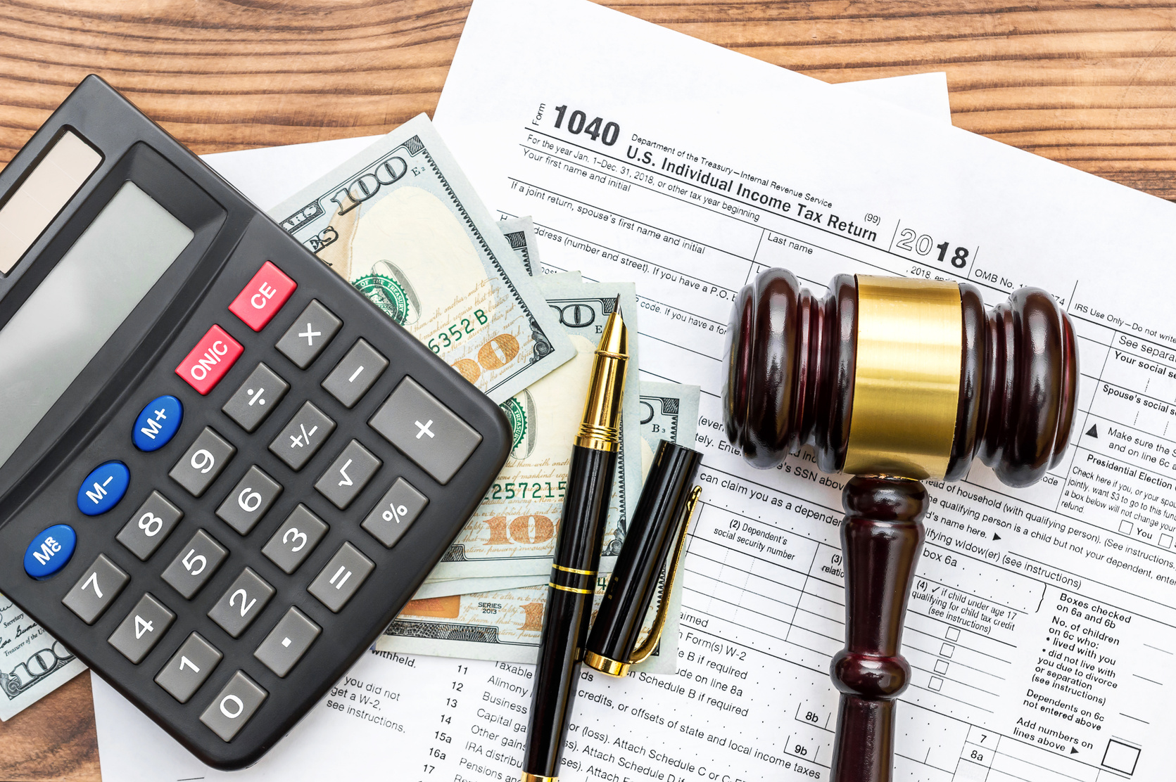 Gavel with calculator and money  on tax form. Top view. Tax law.